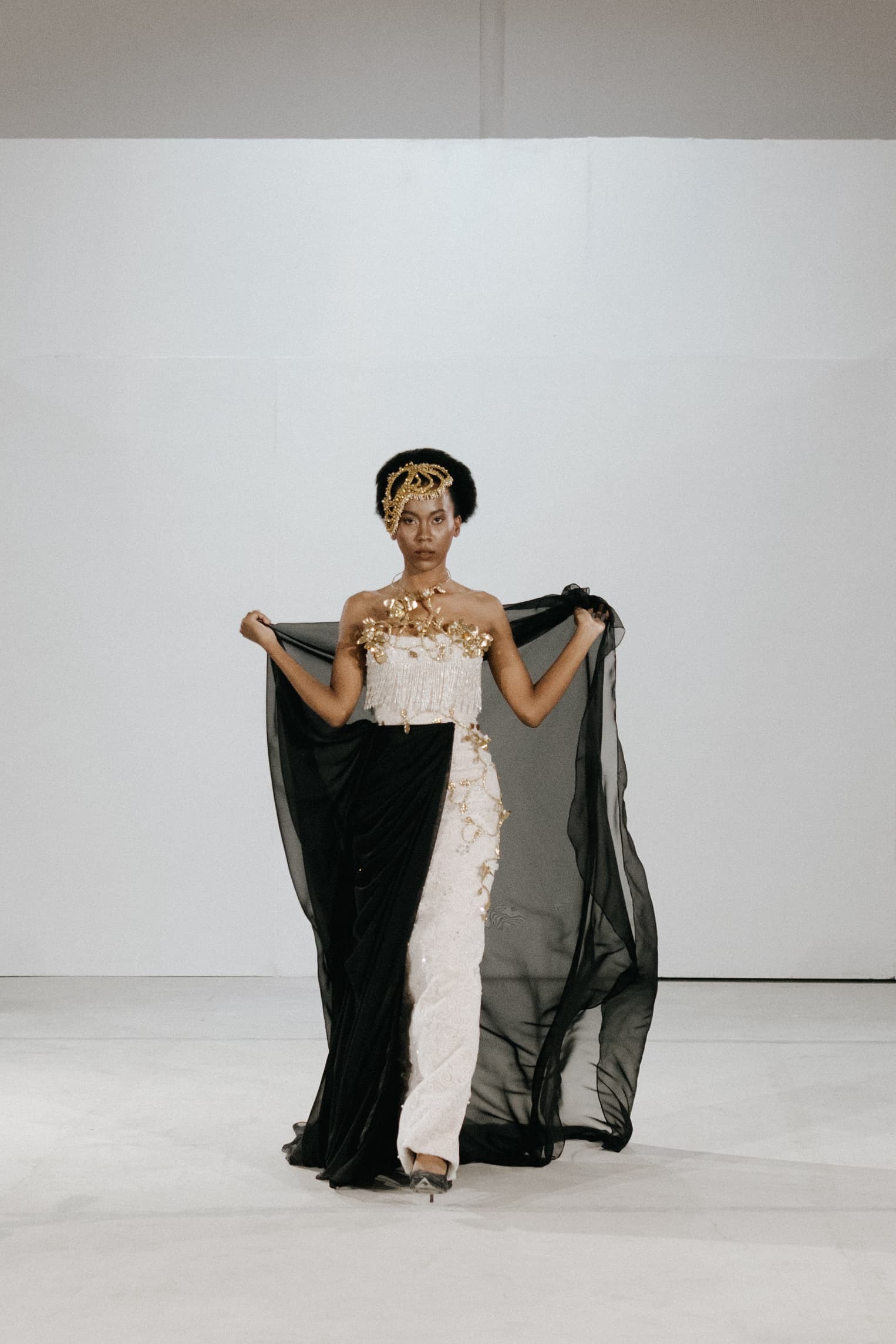 Couture gown with a black drape at a fashion show